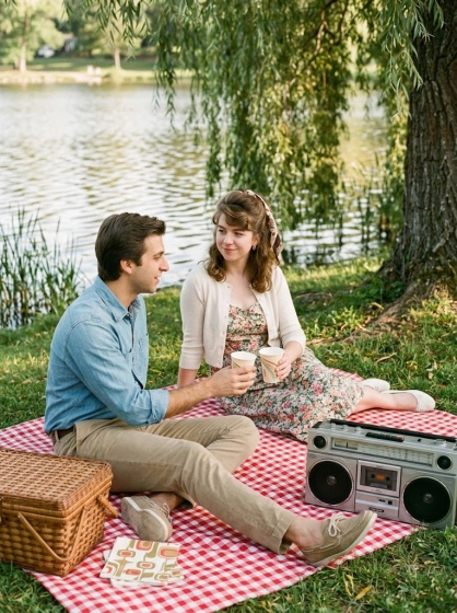 1980s couple having a lakeside picnic beside a cassette boombox